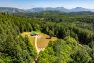 An aerial view of the Cow Barn at Pasado’s Safe Haven. It is surrounded by dense forrest.