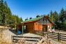 The exterior gates at the Cow Barn at Pasado’s Safe Haven. The Cow Barn is in the background and cedar siding, a green roof, and large windows under the gable roof.