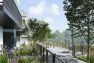 A digital rendering of Stone Avenue Townhomes, a townhome and mid-rise multifamily development in Seattle, Washington. This view shows the incorporated walking and biking path, with townhomes to the left, their gardens abutting the path, and benches overlooking the beautified water detention area to the right.